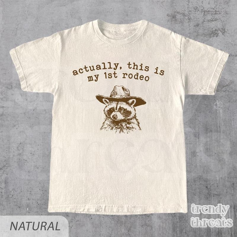 Actually, This Is My First Rodeo T-Shirt | Funny Western Graphic Tee | Raccoon Quote | Retro Shirt Unique Gift Idea |...